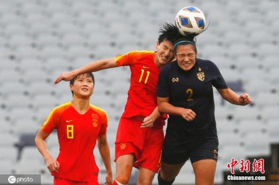 资料图：中国女足6:1大胜泰国的奥预赛比赛中，前锋王珊珊与对手头球争顶。